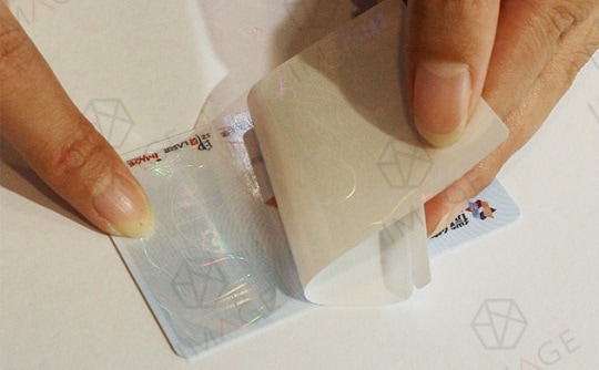 Stick the holographic overlay onto the ID card manually